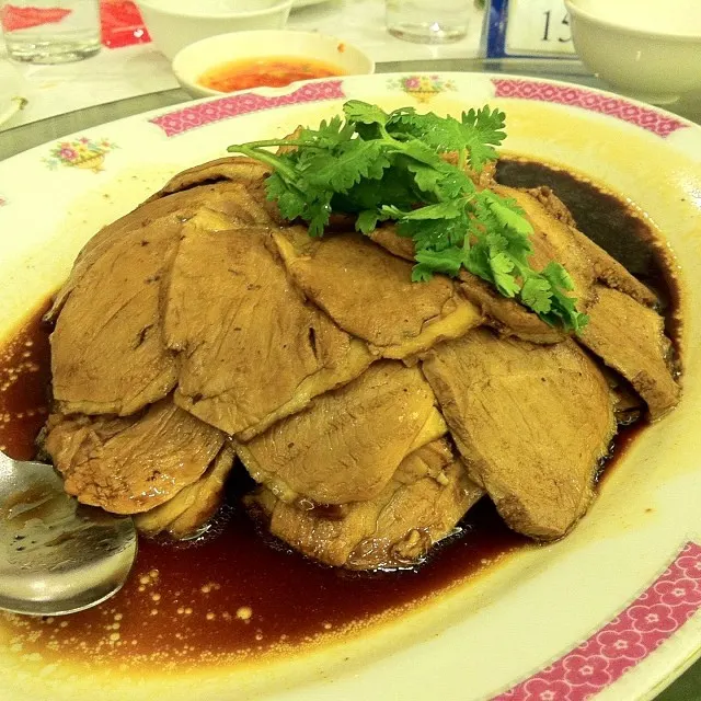 白盘里切件的卤鹅，上撒香菜