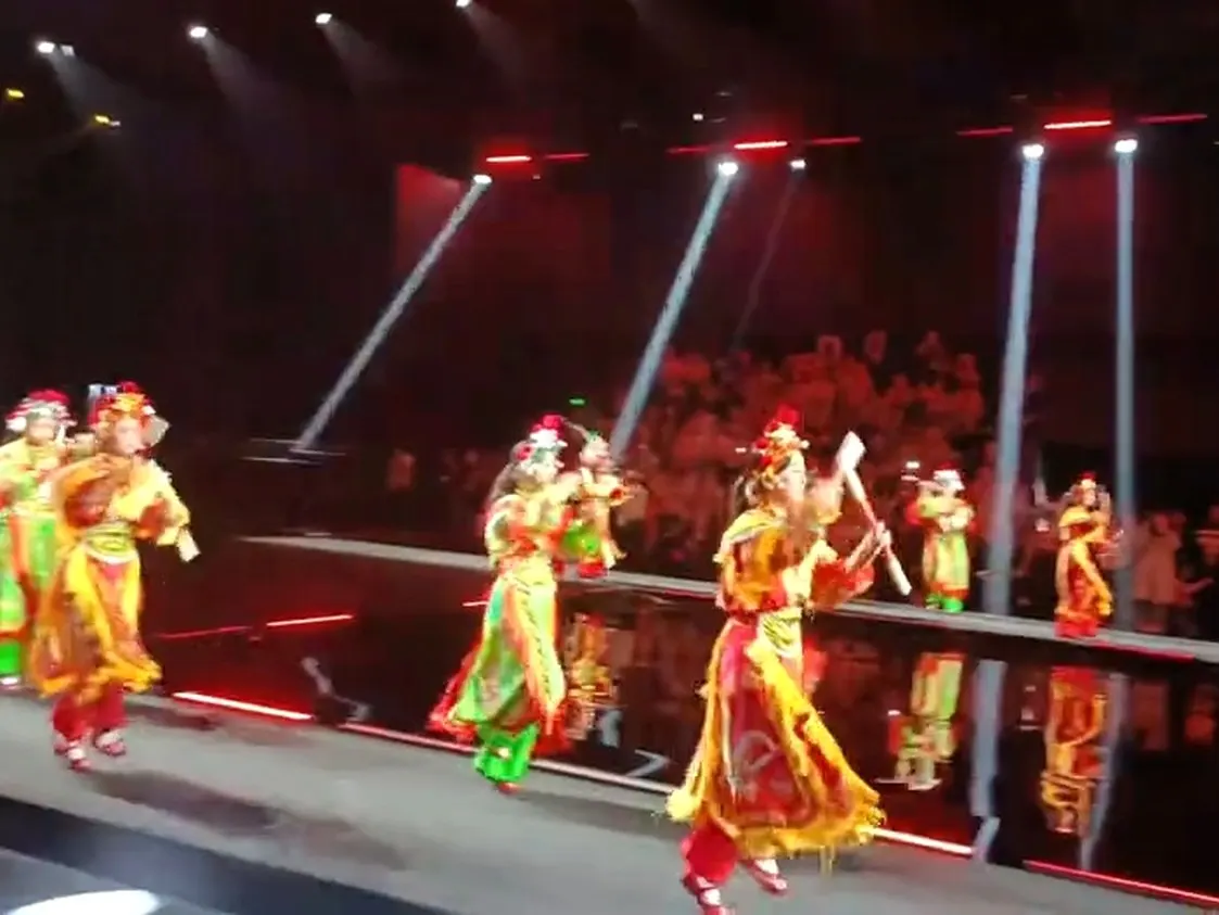 舞臺上燈光壓成紅色,一隊人正在演