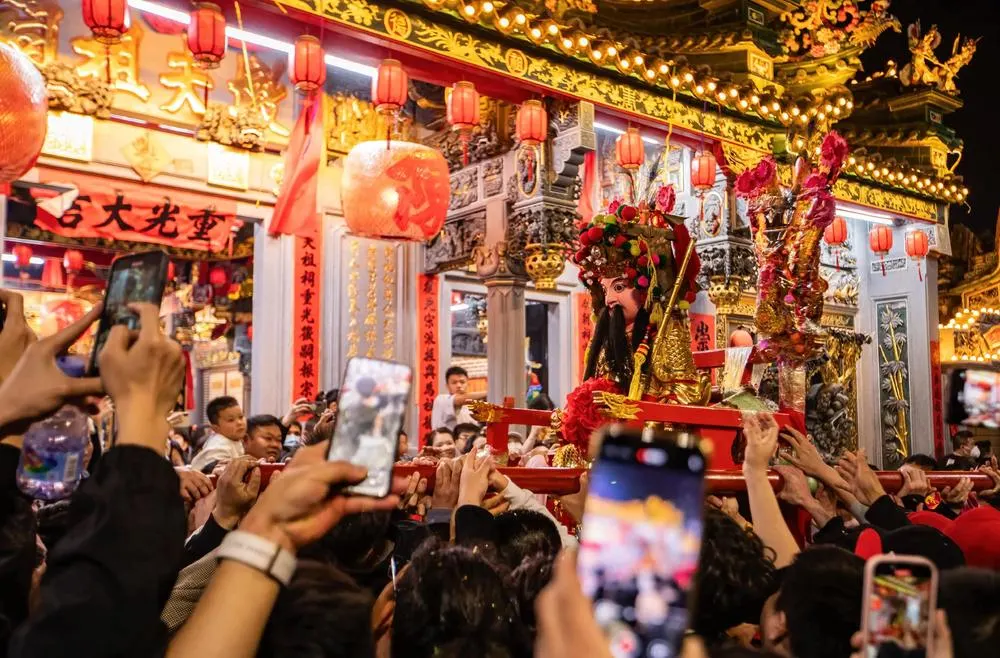 老爷神轿前，人群举手机拍摄