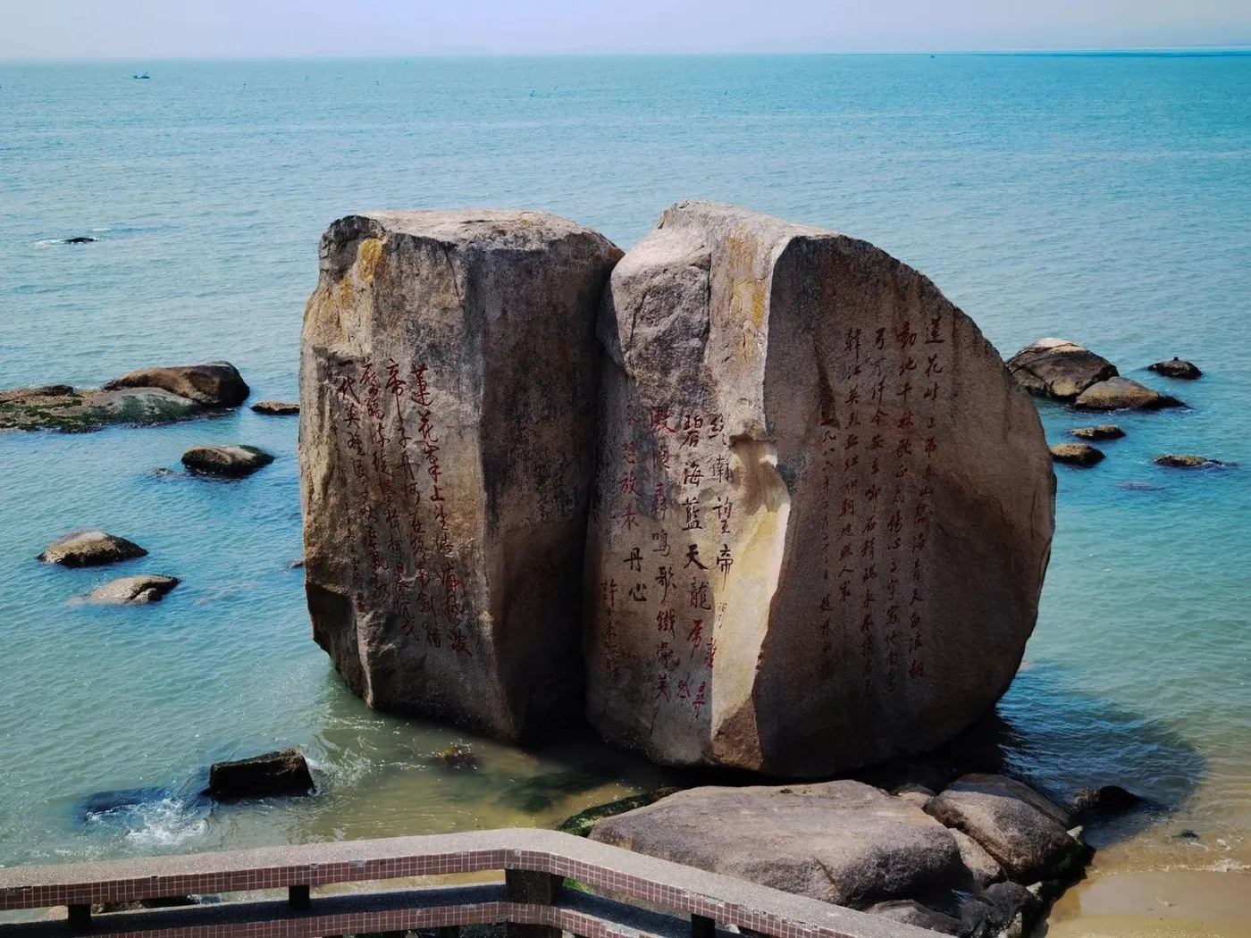 立于海水中的两块巨岩,岩面刻满历代题字