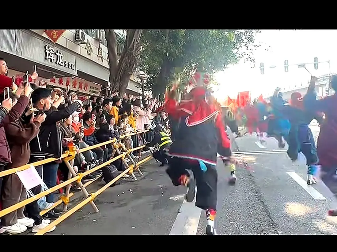 队伍沿街推进，两侧站满观众