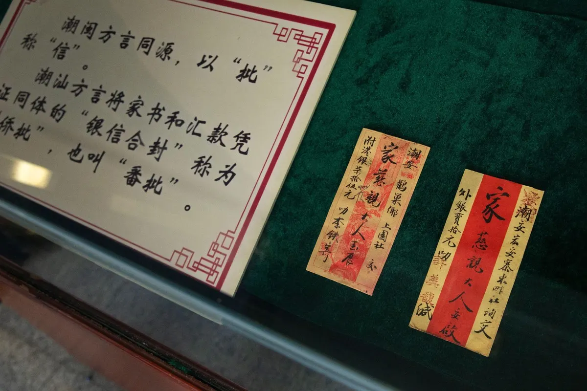 展柜内一块说明牌，旁列两封竖排侨批，绿绒衬底