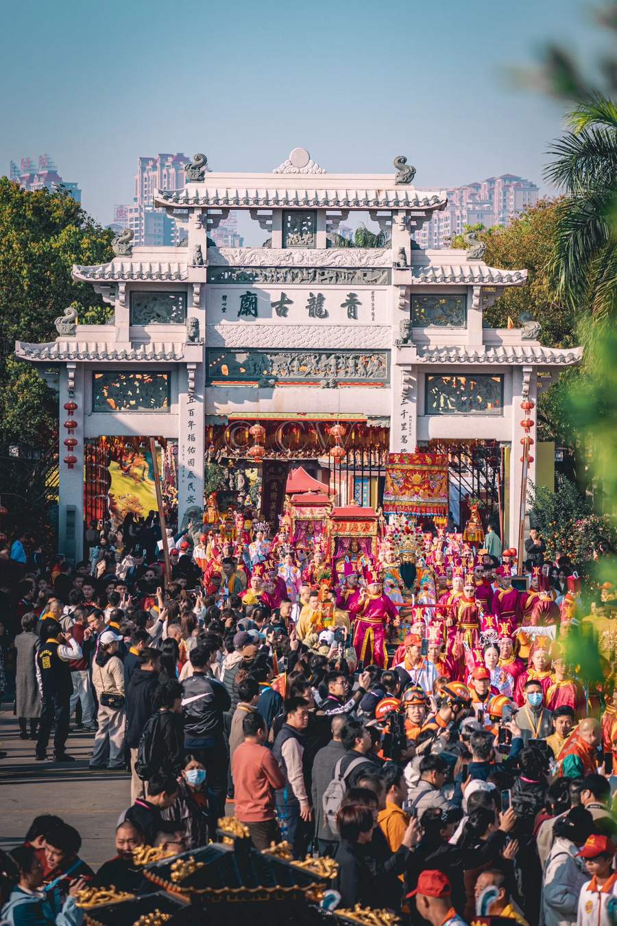 石牌坊前队伍经过,两侧站满人