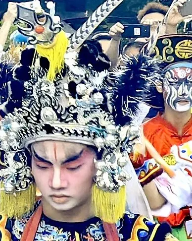 盔头缀满珠串,冠后插两支长雉尾