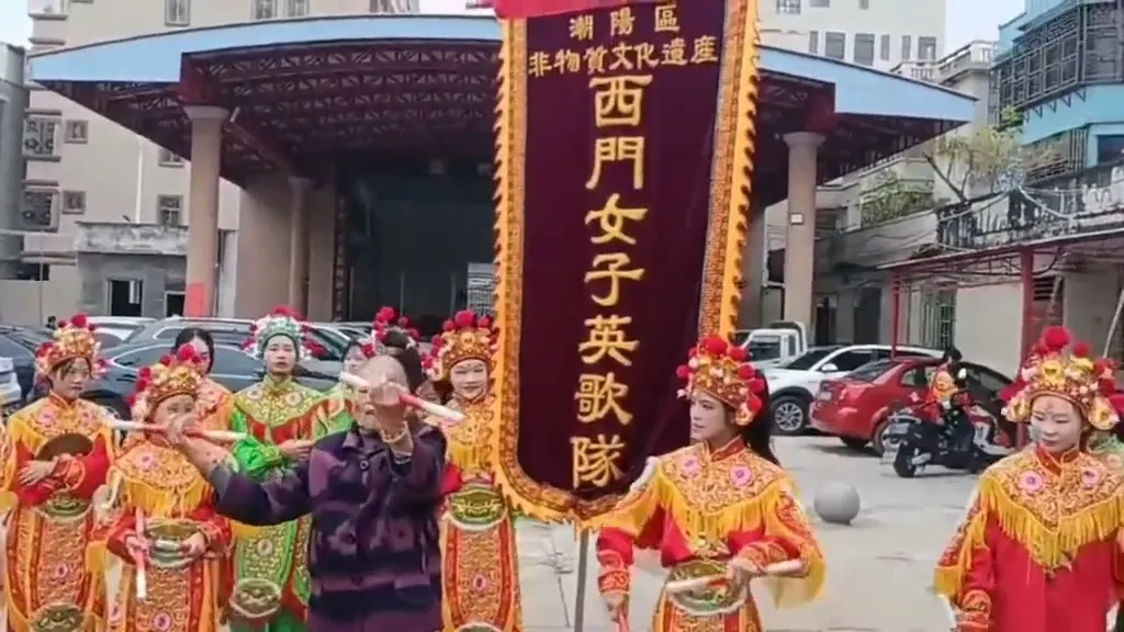 老队员举槌示范，队员执槌围看