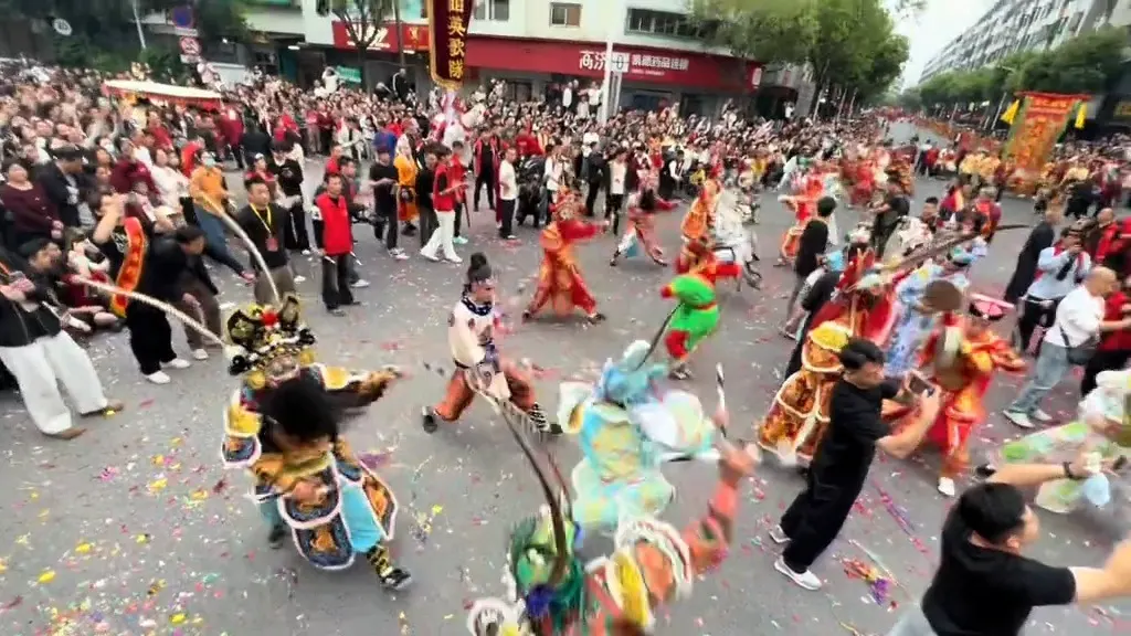 街上大隊行進，地上鋪著一層彩色炮仗紙屑